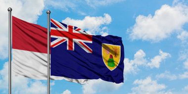 Monako ve Turks ve Caicos Adaları bayrağı birlikte beyaz bulutlu mavi gökyüzüne karşı rüzgarsal sallayarak. Diplomasi kavramı, uluslararası ilişkiler.