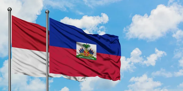 Monaco en Haïti vlag zwaaien in de wind tegen witte bewolkte blauwe hemel samen. Diplomatie concept, internationale betrekkingen. — Stockfoto