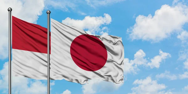 Monaco dan bendera Jepang melambai dalam angin melawan langit biru putih bersama-sama. Konsep diplomasi, hubungan internasional . — Stok Foto