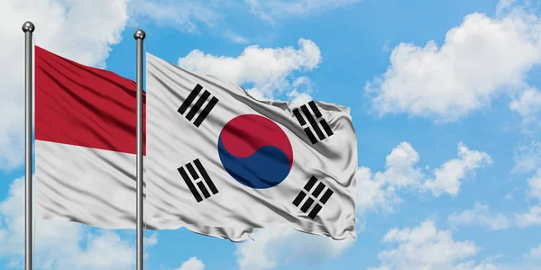 Bandera de Mónaco y Corea del Sur ondeando en el viento contra el cielo azul nublado blanco juntos. Concepto diplomático, relaciones internacionales . —  Fotos de Stock