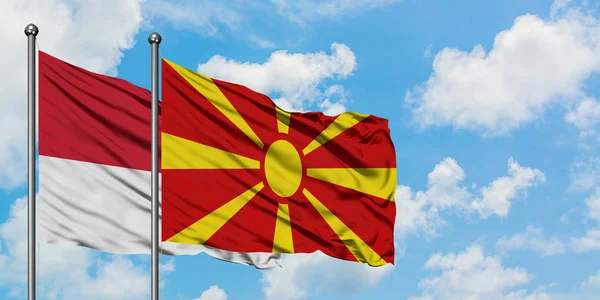 Mônaco e Macedônia acenando com o vento contra o céu azul nublado branco juntos. Conceito de diplomacia, relações internacionais . — Fotografia de Stock
