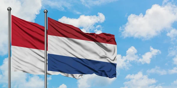 Monaco and Netherlands flag waving in the wind against white cloudy blue sky together. Diplomacy concept, international relations. — Stock Photo, Image