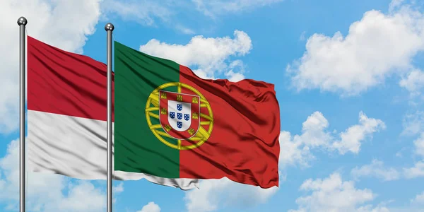 Bandera de Mónaco y Portugal ondeando en el viento contra el cielo azul nublado blanco juntos. Concepto diplomático, relaciones internacionales . — Foto de Stock