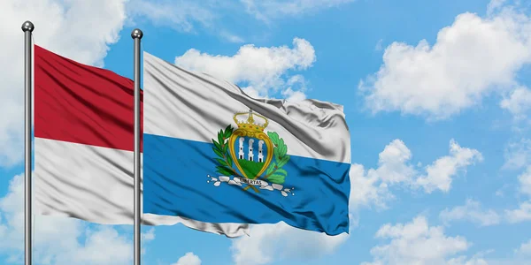 Bandera de Mónaco y San Marino ondeando en el viento contra el cielo azul nublado blanco juntos. Concepto diplomático, relaciones internacionales . — Foto de Stock