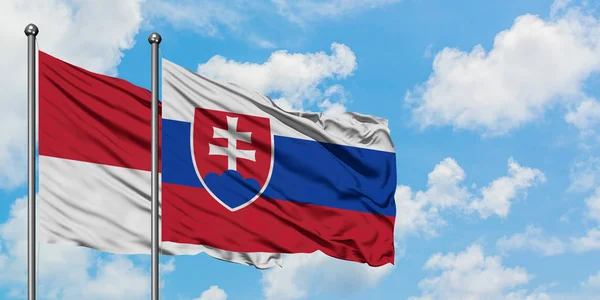 摩纳哥和斯洛伐克国旗在风中飘扬，与白云蓝天相逢。外交概念、国际关系. — 图库照片