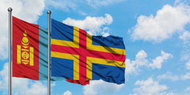 Moğolistan ve Aland Adaları bayrağı birlikte beyaz bulutlu mavi gökyüzüne karşı rüzgarda sallayarak. Diplomasi kavramı, uluslararası ilişkiler.