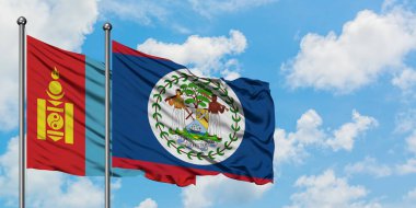 Moğolistan ve Belize bayrağı birlikte beyaz bulutlu mavi gökyüzüne karşı rüzgarda sallayarak. Diplomasi kavramı, uluslararası ilişkiler.