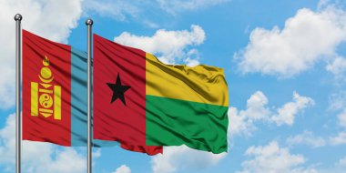 Moğolistan ve Gine Bissau bayrağı birlikte beyaz bulutlu mavi gökyüzüne karşı rüzgarda sallayarak. Diplomasi kavramı, uluslararası ilişkiler.