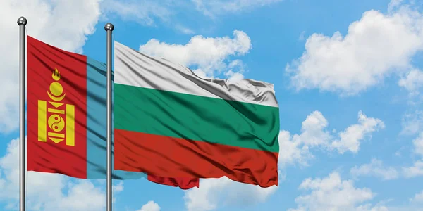 Bandera de Mongolia y Bulgaria ondeando en el viento contra el cielo azul nublado blanco juntos. Concepto diplomático, relaciones internacionales . — Foto de Stock