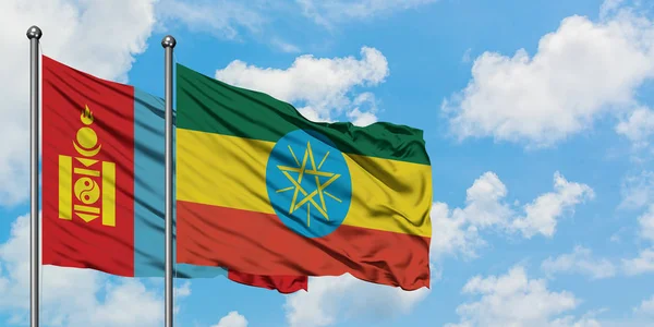 モンゴルとエチオピアの旗が一緒に白い曇り青い空に対して風に振る。外交概念、国際関係. — ストック写真