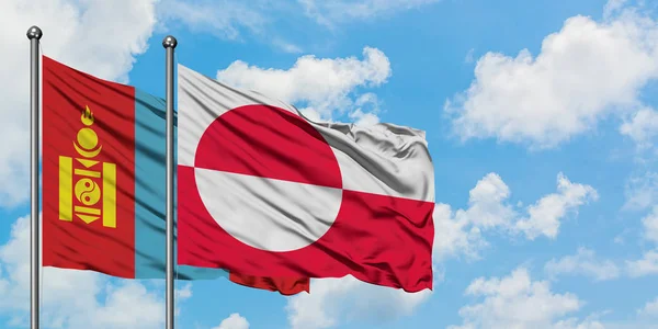 Mongolsko a Grónská vlajka mávali ve větru proti bíle zatažené modré obloze. Diplomacie, mezinárodní vztahy. — Stock fotografie