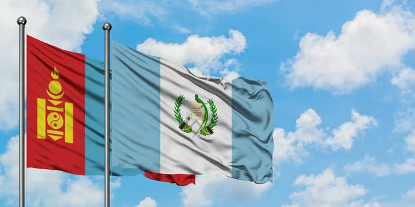 Bandera de Mongolia y Guatemala ondeando en el viento contra el cielo azul nublado blanco juntos. Concepto diplomático, relaciones internacionales . — Foto de Stock