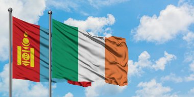 Moğolistan ve İrlanda bayrağı birlikte beyaz bulutlu mavi gökyüzüne karşı rüzgarda sallayarak. Diplomasi kavramı, uluslararası ilişkiler.