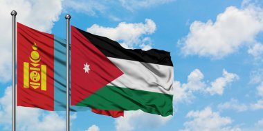 Moğolistan ve Ürdün bayrağı birlikte beyaz bulutlu mavi gökyüzüne karşı rüzgarda sallayarak. Diplomasi kavramı, uluslararası ilişkiler.