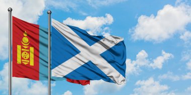 Moğolistan ve İskoçya bayrağı birlikte beyaz bulutlu mavi gökyüzüne karşı rüzgarda sallayarak. Diplomasi kavramı, uluslararası ilişkiler.