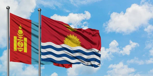 Bandera de Mongolia y Kiribati ondeando en el viento contra el cielo azul nublado blanco juntos. Concepto diplomático, relaciones internacionales . — Foto de Stock