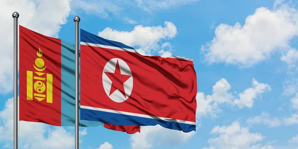 Mongólia e bandeira da Coreia do Norte agitando no vento contra o céu azul nublado branco juntos. Conceito de diplomacia, relações internacionais . — Fotografia de Stock