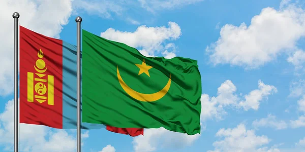 Bandera de Mongolia y Mauritania ondeando en el viento contra el cielo azul nublado blanco juntos. Concepto diplomático, relaciones internacionales . — Foto de Stock