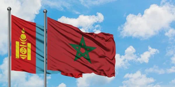 Drapeau de Mongolie et du Maroc agitant dans le vent contre ciel bleu nuageux blanc ensemble. Concept de diplomatie, relations internationales . — Photo