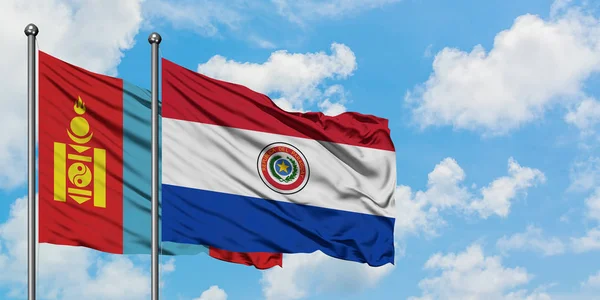 Bandera de Mongolia y Paraguay ondeando en el viento contra el cielo azul nublado blanco juntos. Concepto diplomático, relaciones internacionales . — Foto de Stock