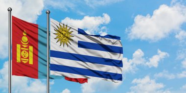 Moğolistan ve Uruguay bayrağı birlikte beyaz bulutlu mavi gökyüzüne karşı rüzgarda sallayarak. Diplomasi kavramı, uluslararası ilişkiler.