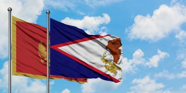 Karadağ ve Amerikan Samoası bayrağı birlikte beyaz bulutlu mavi gökyüzüne karşı rüzgarda sallayarak. Diplomasi kavramı, uluslararası ilişkiler.