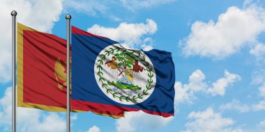 Karadağ ve Belize bayrağı birlikte beyaz bulutlu mavi gökyüzüne karşı rüzgarda sallayarak. Diplomasi kavramı, uluslararası ilişkiler.