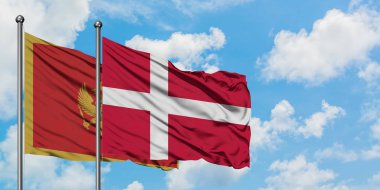 Karadağ ve Danimarka bayrağı birlikte beyaz bulutlu mavi gökyüzüne karşı rüzgarda sallayarak. Diplomasi kavramı, uluslararası ilişkiler.