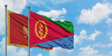 Karadağ ve Eritre bayrağı birlikte beyaz bulutlu mavi gökyüzüne karşı rüzgarda sallayarak. Diplomasi kavramı, uluslararası ilişkiler.