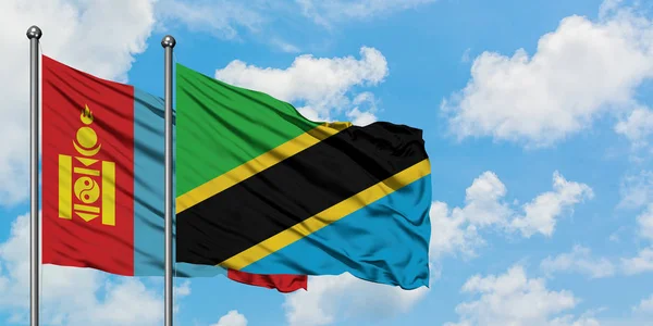 Mongolië en Tanzania vlag zwaaien in de wind tegen witte bewolkte blauwe hemel samen. Diplomatie concept, internationale betrekkingen. — Stockfoto