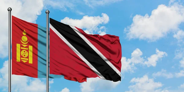 Moğolistan ve Trinidad ve Tobago bayrağı birlikte beyaz bulutlu mavi gökyüzüne karşı rüzgarda sallayarak. Diplomasi kavramı, uluslararası ilişkiler. — Stok fotoğraf