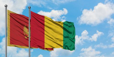 Karadağ ve Gine bayrağı birlikte beyaz bulutlu mavi gökyüzüne karşı rüzgarsal sallayarak. Diplomasi kavramı, uluslararası ilişkiler.