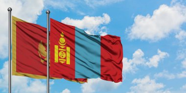 Karadağ ve Moğolistan bayrağı birlikte beyaz bulutlu mavi gökyüzüne karşı rüzgarda sallayarak. Diplomasi kavramı, uluslararası ilişkiler.