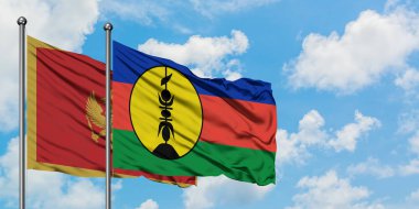 Karadağ ve Yeni Kaledonya bayrağı birlikte beyaz bulutlu mavi gökyüzüne karşı rüzgarda sallayarak. Diplomasi kavramı, uluslararası ilişkiler.