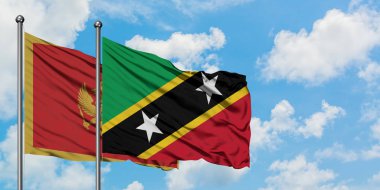 Karadağ ve Saint Kitts ve Nevis bayrağı birlikte beyaz bulutlu mavi gökyüzüne karşı rüzgarda sallayarak. Diplomasi kavramı, uluslararası ilişkiler.
