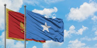 Karadağ ve Somali bayrağı birlikte beyaz bulutlu mavi gökyüzüne karşı rüzgarsal sallayarak. Diplomasi kavramı, uluslararası ilişkiler.