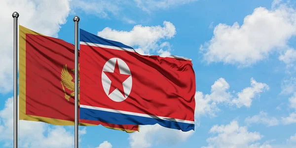Karadağ ve Kuzey Kore bayrağı birlikte beyaz bulutlu mavi gökyüzüne karşı rüzgarsal sallayarak. Diplomasi kavramı, uluslararası ilişkiler. — Stok fotoğraf