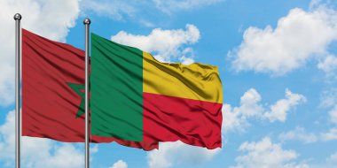 Fas ve Benin bayrağı birlikte beyaz bulutlu mavi gökyüzüne karşı rüzgarsal sallayarak. Diplomasi kavramı, uluslararası ilişkiler.