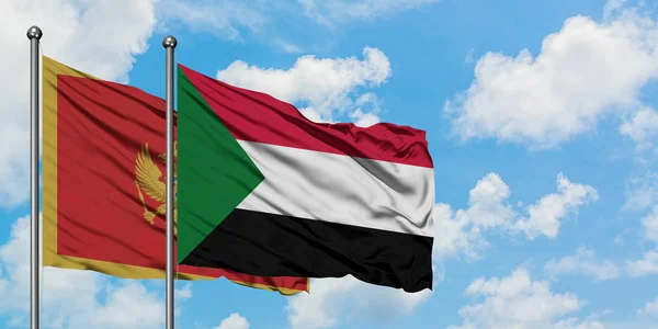 Bandera de Montenegro y Sudán ondeando en el viento contra el cielo azul nublado blanco juntos. Concepto diplomático, relaciones internacionales . — Foto de Stock
