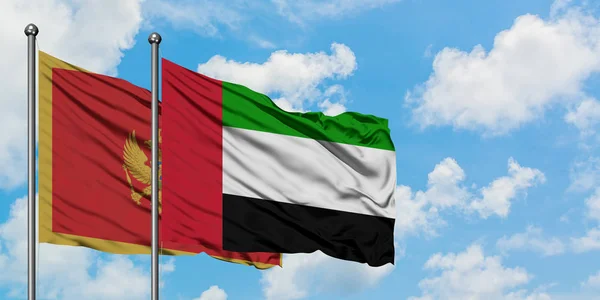 Montenegro y la bandera de los Emiratos Árabes Unidos ondeando en el viento contra el cielo azul nublado blanco juntos. Concepto diplomático, relaciones internacionales . — Foto de Stock