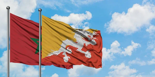 Bandera de Marruecos y Bután ondeando en el viento contra el blanco cielo azul nublado juntos. Concepto diplomático, relaciones internacionales . — Foto de Stock