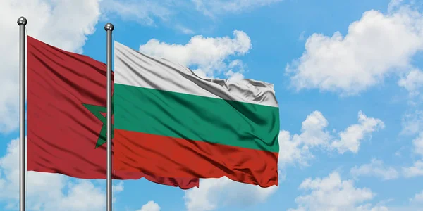 Bandera de Marruecos y Bulgaria ondeando en el viento contra el cielo azul nublado blanco juntos. Concepto diplomático, relaciones internacionales . — Foto de Stock
