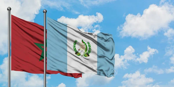 Marocko och Guatemala sjunker vifta i vinden mot vit grumlig blå himmel tillsammans. Diplomatisk koncept, internationella relationer. — Stockfoto