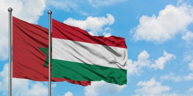 Fas ve Macaristan bayrağı birlikte beyaz bulutlu mavi gökyüzüne karşı rüzgarsal sallayarak. Diplomasi kavramı, uluslararası ilişkiler.