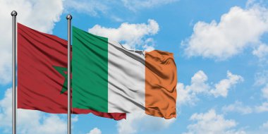 Fas ve İrlanda bayrağı birlikte beyaz bulutlu mavi gökyüzüne karşı rüzgarda sallayarak. Diplomasi kavramı, uluslararası ilişkiler.