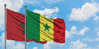 Fas ve Senegal bayrağı birlikte beyaz bulutlu mavi gökyüzüne karşı rüzgarsal sallayarak. Diplomasi kavramı, uluslararası ilişkiler.