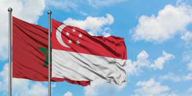 Fas ve Singapur bayrağı birlikte beyaz bulutlu mavi gökyüzüne karşı rüzgarda sallayarak. Diplomasi kavramı, uluslararası ilişkiler.