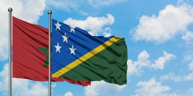 Fas ve Solomon Adaları bayrağı birlikte beyaz bulutlu mavi gökyüzüne karşı rüzgarsal sallayarak. Diplomasi kavramı, uluslararası ilişkiler.