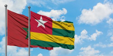 Fas ve Togo bayrağı birlikte beyaz bulutlu mavi gökyüzüne karşı rüzgarda sallayarak. Diplomasi kavramı, uluslararası ilişkiler.