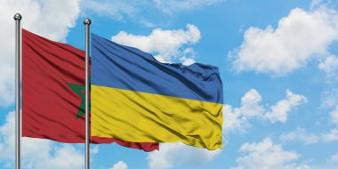 Fas ve Ukrayna bayrağı birlikte beyaz bulutlu mavi gökyüzüne karşı rüzgarsal sallayarak. Diplomasi kavramı, uluslararası ilişkiler.